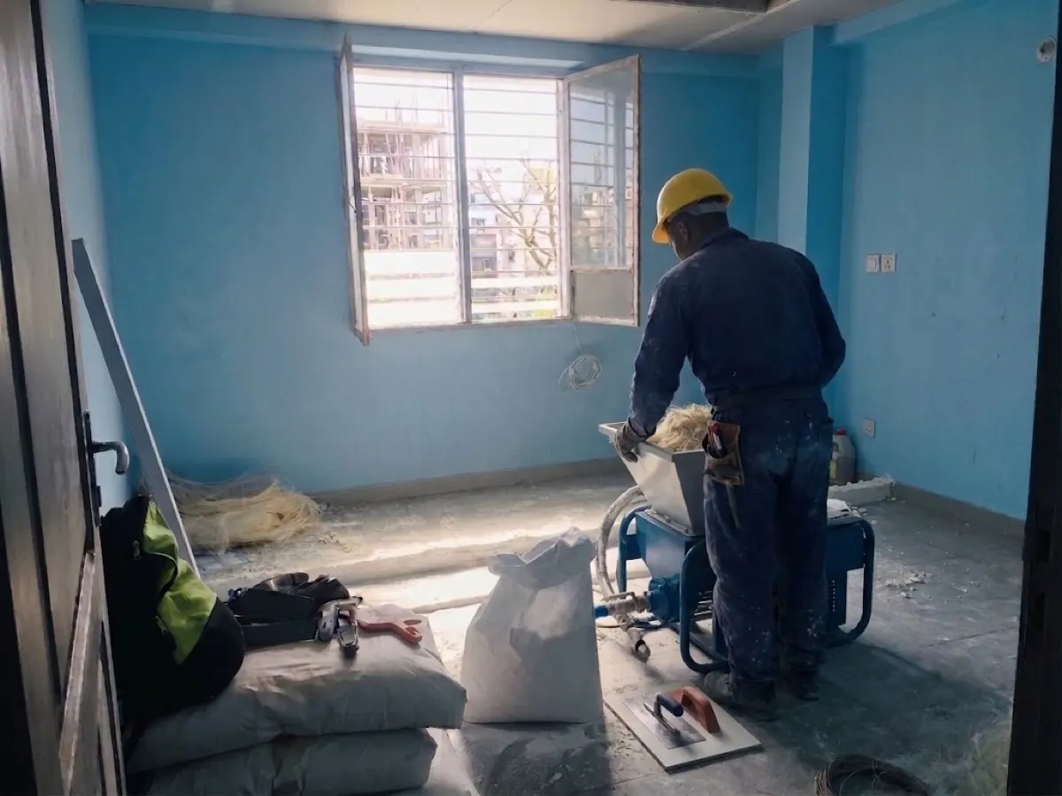 Le séjour du T2 en chantier, murs bleus, enduit en cours